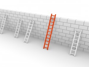 Ladders against a wall, one larger than the rest