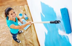 Woman painting a wall in a house