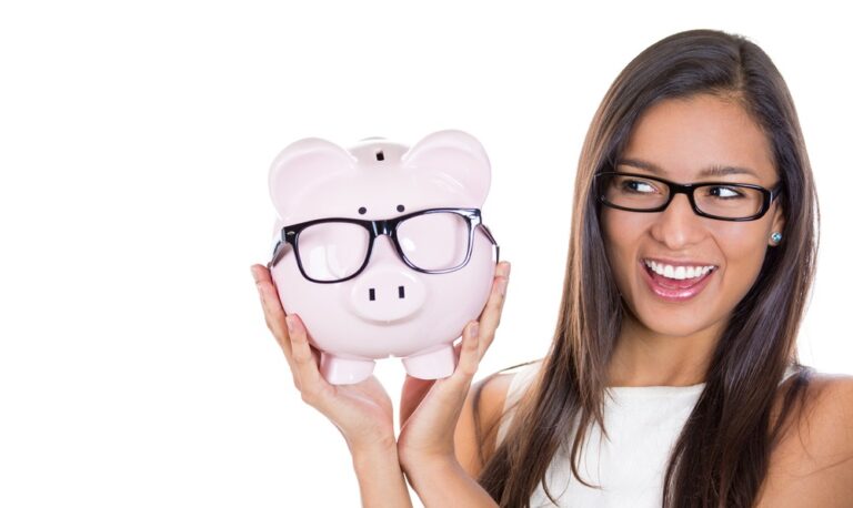 Young woman holding a piggy bank wearing glasses.
