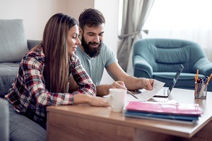Couple discussing finances on a computer