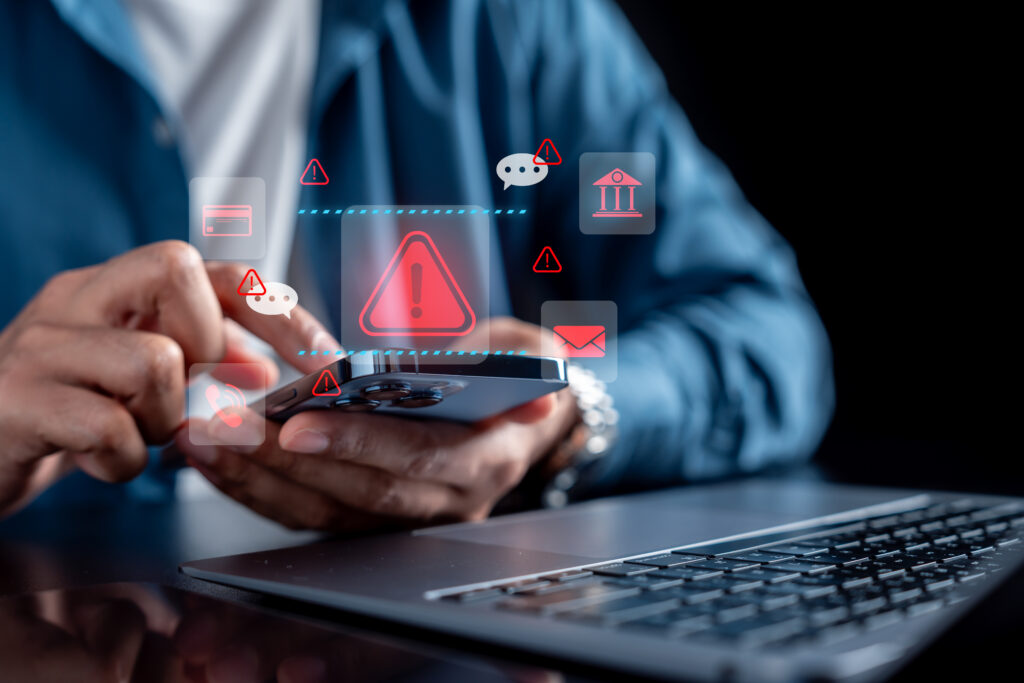 Cybersecurity warning concept with businessman using smartphone and red alert icons, online fraud, phishing scam, data protection, internet security, and digital risk management.